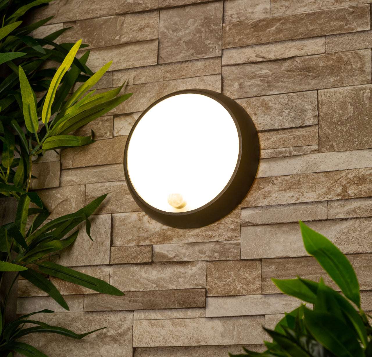 Zara black and white round wall light with motion sensor is an modern simple fitting with a black polycarbonate body and opal diffuser. This stylish wall light is perfect for adding a pinch of modern flavour to doorways, sheds, patios, porch, driveways, garages, sheds, and more. This fitting is IP54 rated which makes it fully weatherproof light fitting.