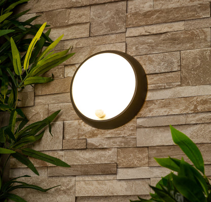 Zara black and white round wall light with motion sensor is an modern simple fitting with a black polycarbonate body and opal diffuser. This stylish wall light is perfect for adding a pinch of modern flavour to doorways, sheds, patios, porch, driveways, garages, sheds, and more. This fitting is IP54 rated which makes it fully weatherproof light fitting.