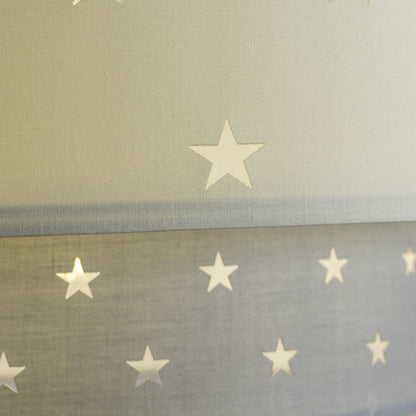 Our Grey and Cream two tiered star shade features a mixture of large and small sweet stars cut out across a grey and cream background. When your lamp is turned on it will shine out through these cut-outs, mimicking a beautiful night sky. This lampshade is made with soft-touch fabric for a little bit of luxury.