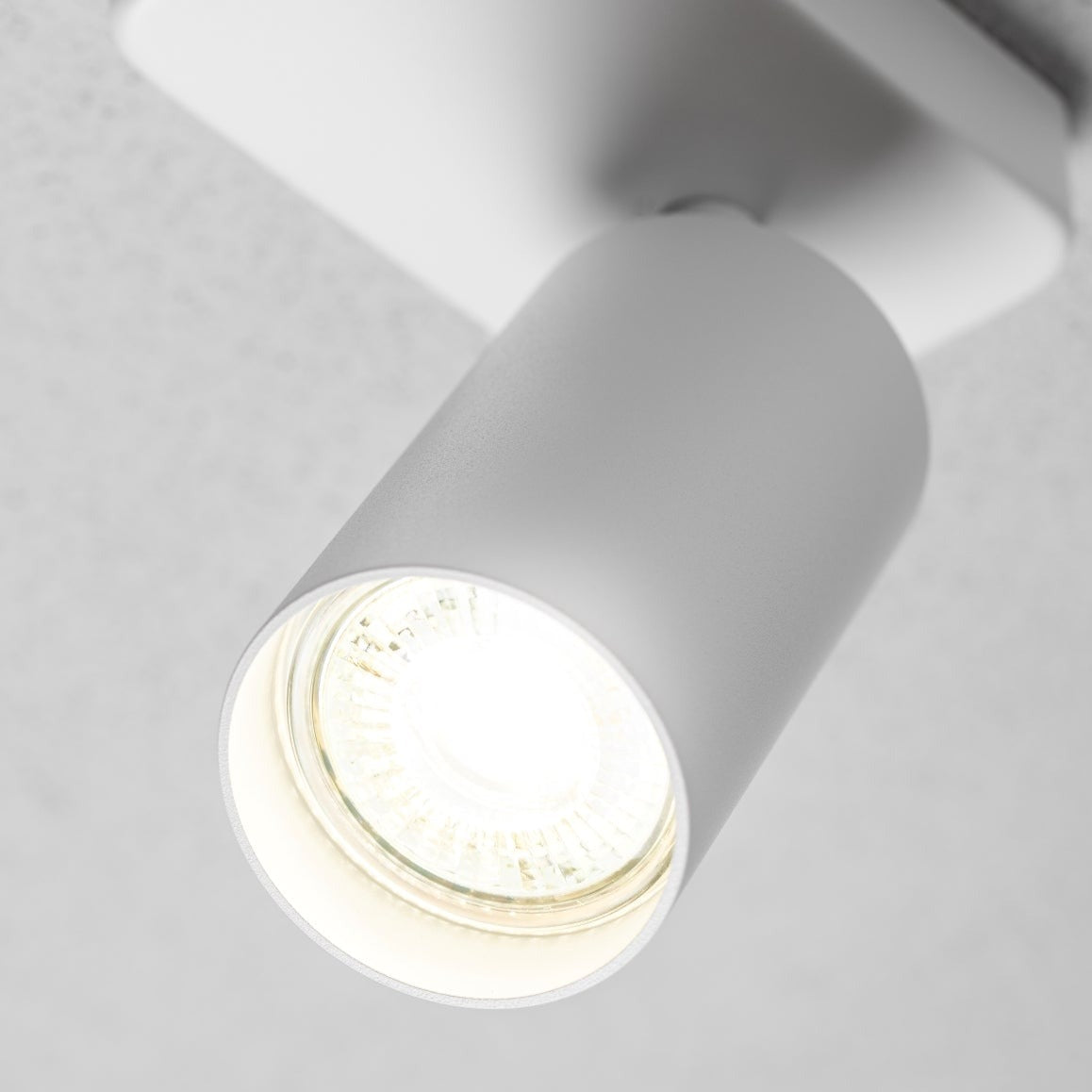 The white Nell lamp consists of a cylindrical spotlight, which can be tilted and adjusted on its own axis. The spotlight is attached to a rectangular bracket, which makes it equally suitable for mounting on walls and ceilings. Made of an aluminium body and powder coated white, the lamp with its simple design fits well into different spaces. 