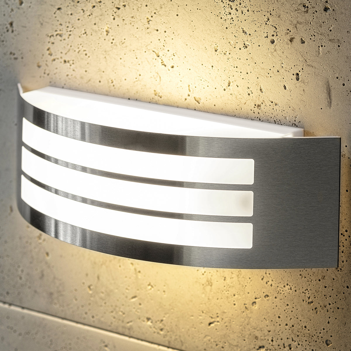 Stylish Striker with a shade made of polycarbonate is a hemispherical outdoor lamp holder, made of stainless steel, decorated with additional, narrower stripes. The surface distributes the light of the lamp softly and evenly, creating an atmospheric, pleasant light even outdoors.