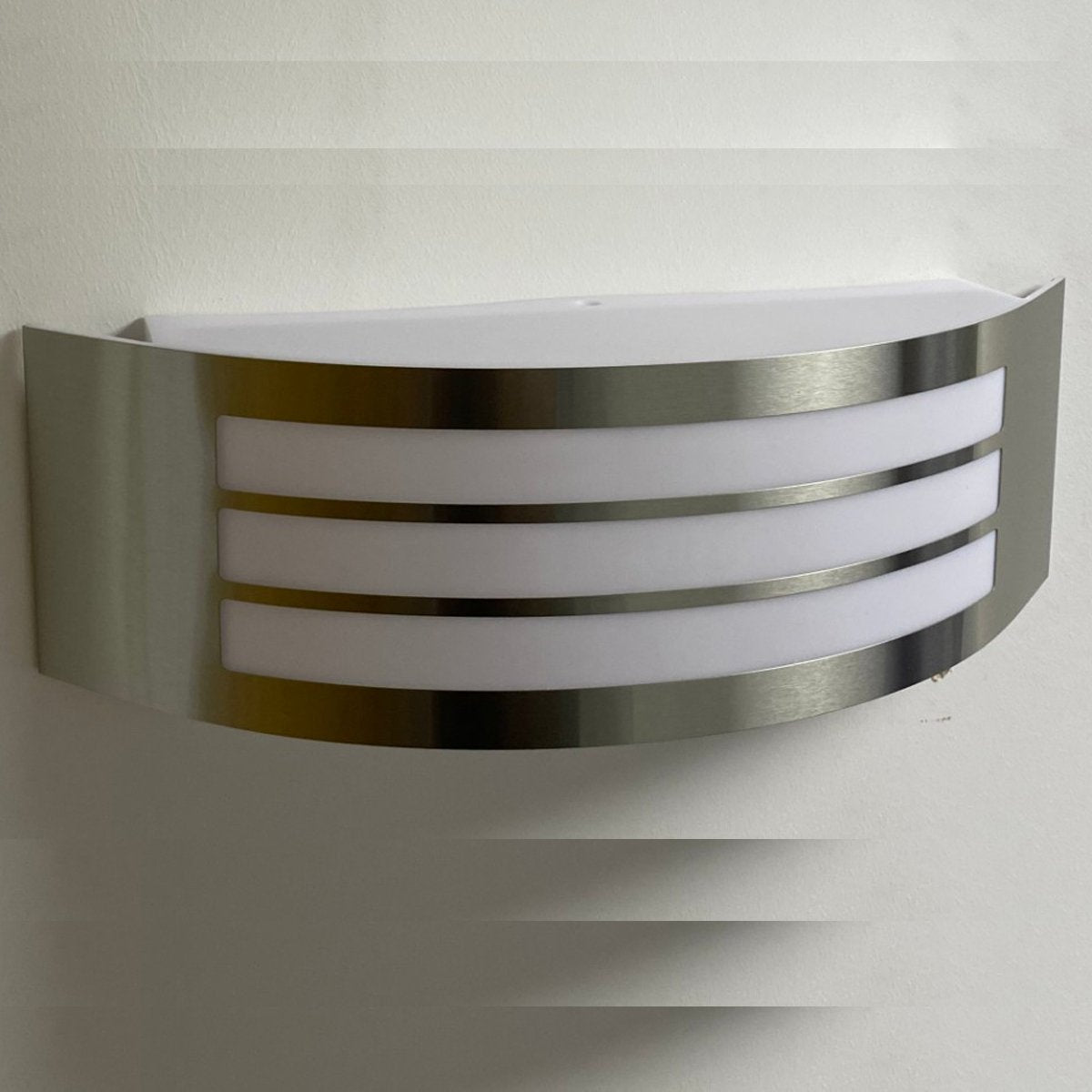Stylish Striker with a shade made of polycarbonate is a hemispherical outdoor lamp holder, made of stainless steel, decorated with additional, narrower stripes. The surface distributes the light of the lamp softly and evenly, creating an atmospheric, pleasant light even outdoors.